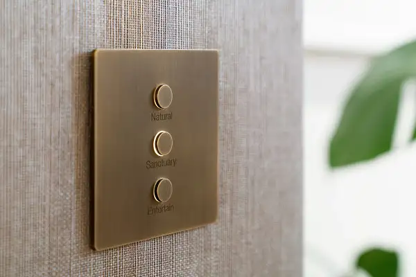 Keypad Lutron Alisse em acabamento bronze sobre revestimento têxtil, com botões gravados